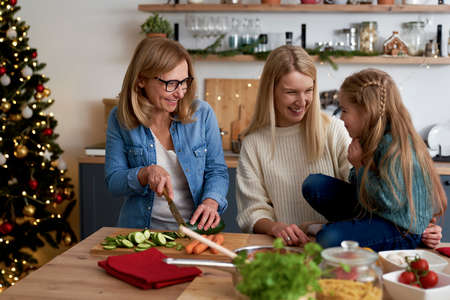 Happy three generations women spending time in the kitchenの写真素材
