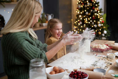 Mother and daughter have fun with flour during Christmas timeの写真素材