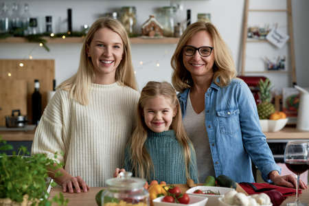 Portrait of three generations of women in kitchen during Christmas timeの写真素材