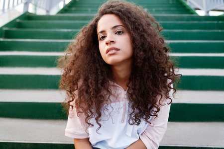 Portrait of beautiful Brazilian woman sitting on the stairsの写真素材