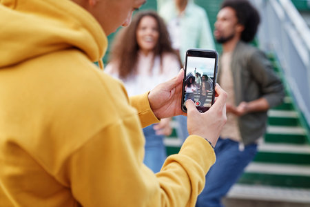 Young man taking pictures of his friendsの写真素材