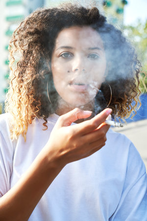 Portrait of young woman smoking cigarette