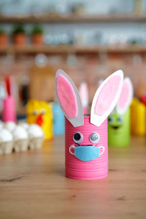 Handmade Easter rabbit in protective face mask on the tableの写真素材