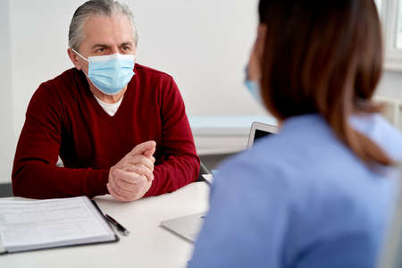 Senior patient in protective face mask in doctor's officeの写真素材