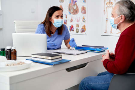 Side view of a doctor talking to an elderly patient