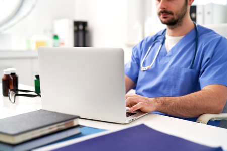Side view of doctor while working on the computer