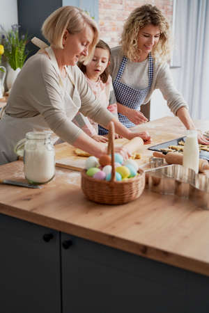Grandmother teaching granddaughter how to make Easter cake