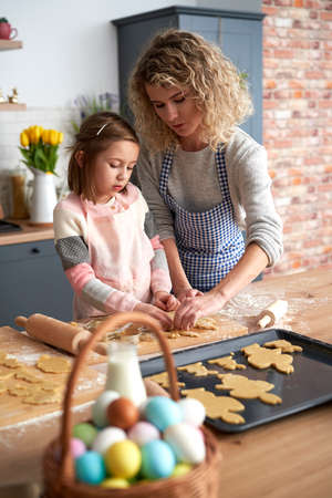 Daughter and mother making Easter cookies at homeの写真素材