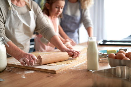 Close up of women rolling dough
