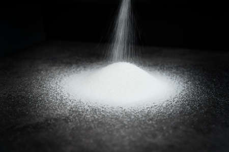 Detail of white sugar poured on blackの写真素材