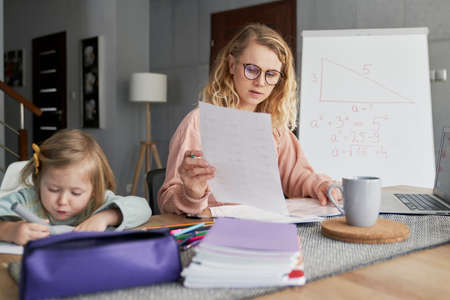 Teacher conducts classes online and takes care of the daughterの写真素材