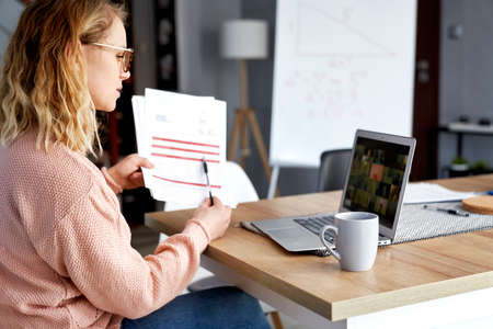 Female teacher conducts online lessons and shows documents