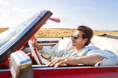Handsome man with sunglasses driving an old carの写真素材