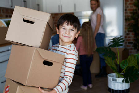 Portrait of smiling boy holding a cardboard boxの写真素材