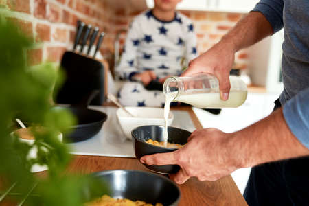 Close up of man preparing breakfast cereal for his sonの写真素材