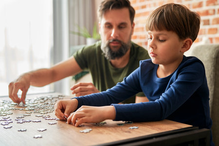 Close up of father and son solving jigsaw puzzleの写真素材