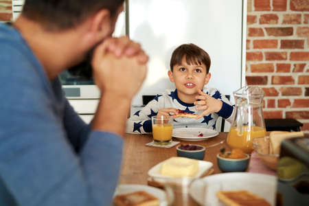 Father and son talking together at breakfastの写真素材