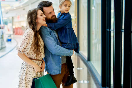 Family stalks through the shop windowの写真素材