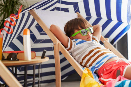 Close up of relaxed boy lying on a chair at home