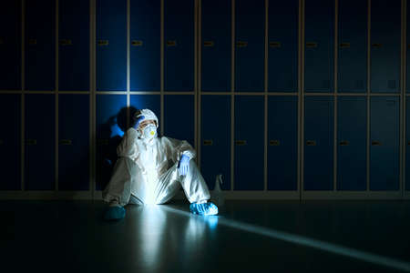 Overworked healthcare worker resting in dark roomの写真素材