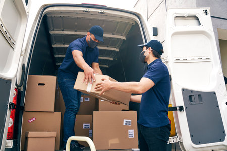 Bottom view of couriers unloading packages during a pandemicの写真素材