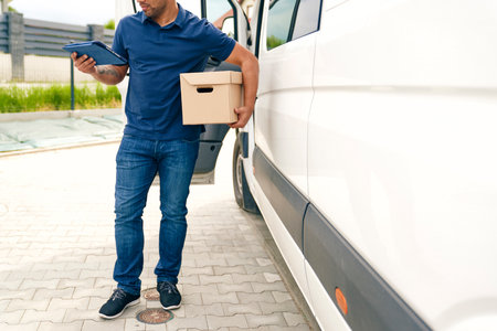 Close up of courier with package and digital tablet