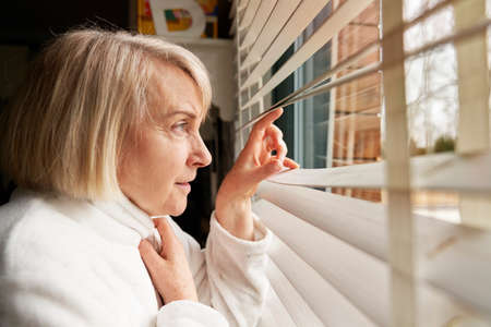 Side view of elderly woman looking out the window