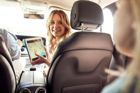 Mother with digital tablet with map in the car