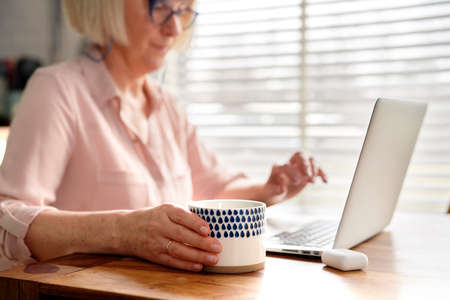 Close up of senior holding coffee cup