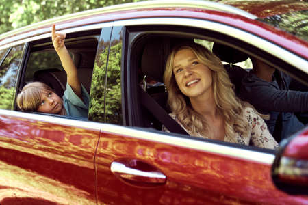 Little girl points with her finger while traveling by car