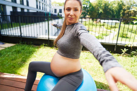 Expectant mother sitting on fitness ballの写真素材