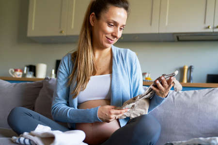 Pregnant woman preparing baby clothes