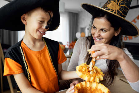 Mom with son making pumpkins for Halloweenの写真素材