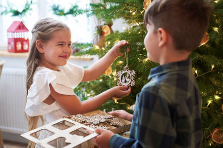 Sibling decorating Christmas tree togetherの写真素材