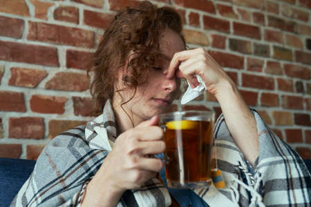 Caucasian woman having a sinus infection and drinking hot teaの写真素材