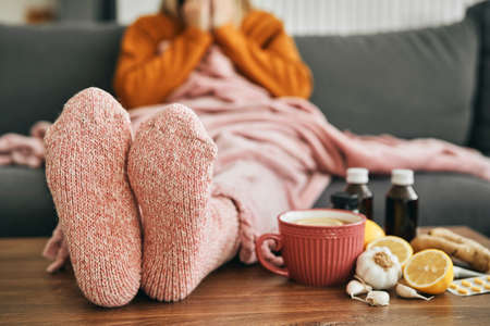 Woman with warm socks having a heavy fluの写真素材