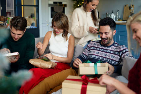 Friends opening received Christmas presentsの写真素材
