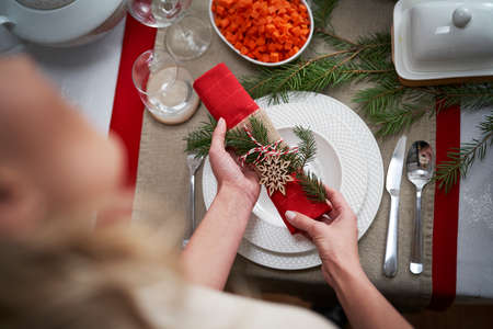 Woman putting napkin on Christmas tableの写真素材