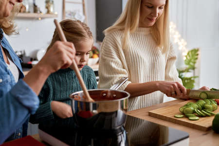 Three generations of women cooking in the kitchenの写真素材