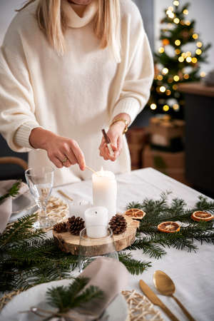 Close up woman lights a candle in Christmas Eveの写真素材