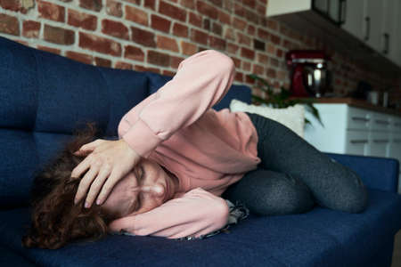 Close up of young caucasian woman suffering from a headacheの写真素材