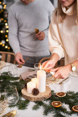 Close up woman lights a candle in Christmas Eveの写真素材