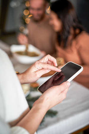 Close up of woman using mobile phone at Christmas Eveの写真素材