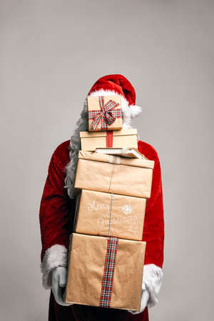 Santa Claus holding holding stack of Christmas presentsの写真素材