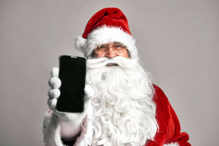 Santa Claus showing screen of mobile phoneの写真素材