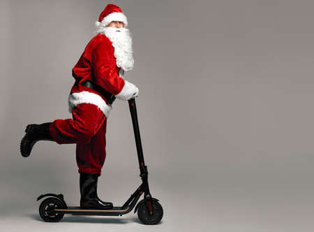 Santa Claus riding an electric scooterの写真素材