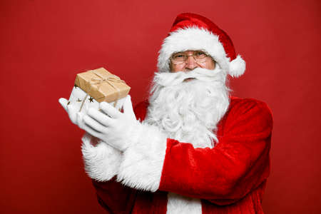 Smiling caucasian Santa Claus holding Christmas presentの写真素材