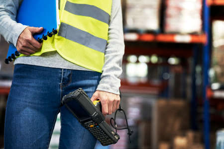 Close up caucasian woman holding information equipment in warehouseの写真素材