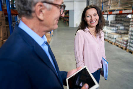Caucasian mature man and woman discussing in a warehouseの写真素材