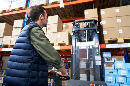 Adult caucasian man working at forklift in warehouseの写真素材